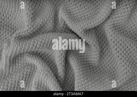 Gray color crumpled, wrinkled knitting wool cloth texture. Background of knitted fabric with dots pattern. Textile structure, cloth surface, weaving o Stock Photo