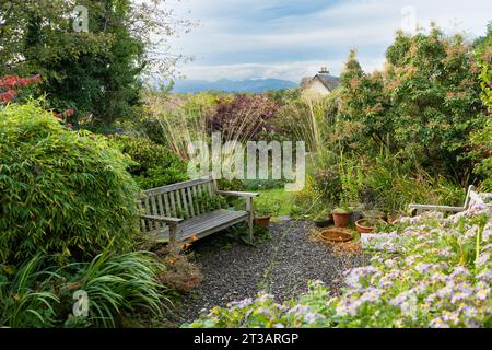 secluded garden seating area in cottage style garden with view - Scotland, UK Stock Photo