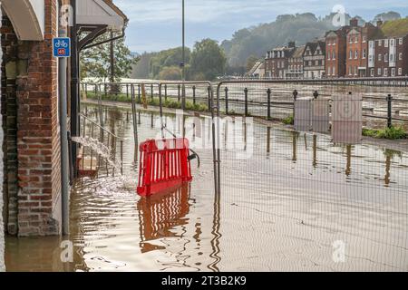 Bewdley, UK. 23rd October, 2023. Bewdley after Storm Babet. River levels remain very high and the flood barriers are still in place as large areas are engulfed by the swollen River Severn. River water floods and closes the road close to the corner to Beales corner where new flood defences sre being installed. Credit: Lee Hudson Stock Photo