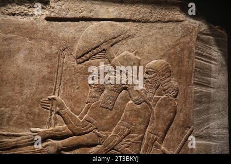 Nimrud palace wall relief (Iraq). Neo-Assyrian Empire. 875-860 BC. Alabaster. The monarch Ashurnasirpal II as a war hero in a chariot accompanied by s Stock Photo