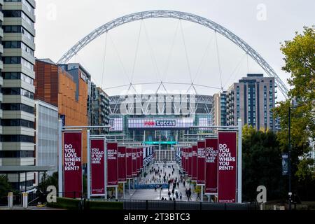 People walking along Olympic Way with the National Football Stadium in the background, Wembley Park, Borough of Brent, London, England, UK Stock Photo