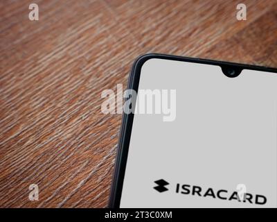 Lod, Israel - July 16,2023: Isracard app launch screen on smartphone on wooden background. Top view flat lay with copy space. Stock Photo