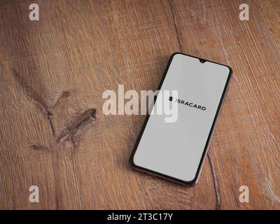 Lod, Israel - July 16,2023: Isracard app launch screen on smartphone on wooden background. Top view flat lay with copy space. Stock Photo