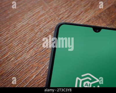 Lod, Israel - July 16,2023: Adam Ai app launch screen on smartphone on wooden background. Top view flat lay with copy space. Stock Photo