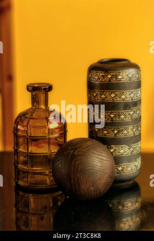 Still life with brownish props on the wooden table against yellowish wall Stock Photo