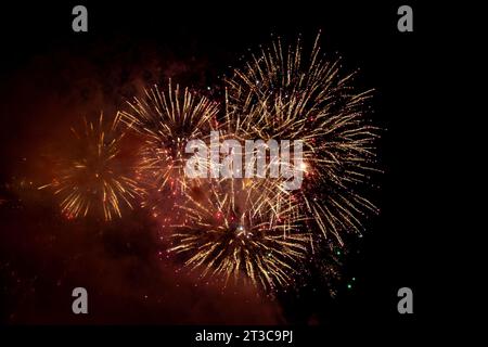 Looking up at exploding fireworks against a night sky Stock Photo