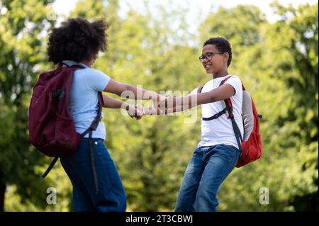 Smiling boy and girl walking hand in hand in the park Stock Photo