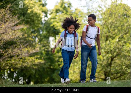 Smiling boy and girl walking hand in hand in the park Stock Photo