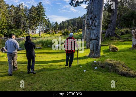 Watchman named Gordie giving tour of Totem poles at UNESCO World Heritage Site Sgang Gwaay Llnagaay, an ancient village site in Gwaii Haanas National Stock Photo