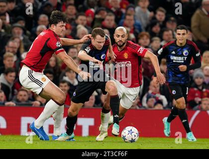 Manchester, UK. 24th Oct, 2023. Harry Maguire (l) and Sofyan Amrabat of Manchester United (r) tackle Viktor Claesson of FC Copenhagen during the UEFA Champions League match at Old Trafford, Manchester. Picture credit should read: Andrew Yates/Sportimage Credit: Sportimage Ltd/Alamy Live News Stock Photo