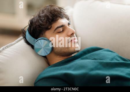 Middle Eastern Man Listening Music Wearing Headphones Resting Indoor Stock Photo