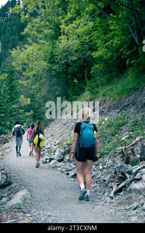 Kandersteg, Switzerland–Aug 3,2023: A white girl hiking on a path in the Alps Stock Photo