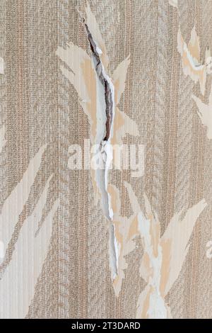 Cracks in an apartment, crack with peeling plaster on a wall Stock Photo