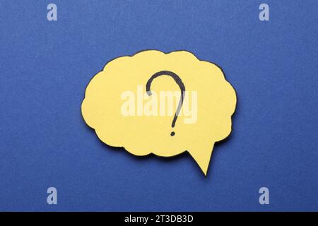 Paper speech bubble with question mark on blue background, top view Stock Photo