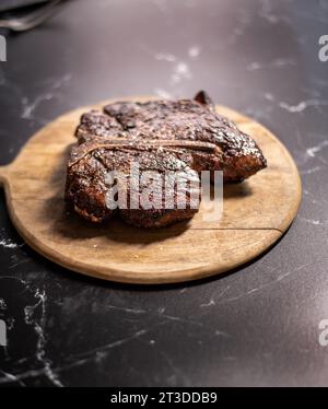 Sizzlling Portehouse steak on a wood board Stock Photo