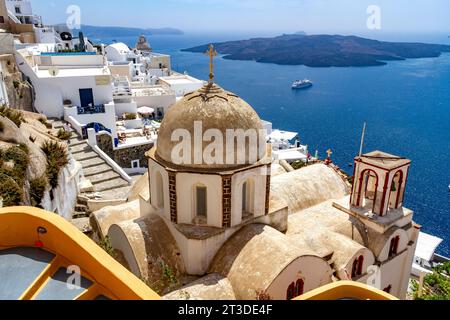 Overlooking the caldera and Aegean sea from the sunwashed Greek island of Santorini from the city of Fira, a domed church in foreground. Stock Photo