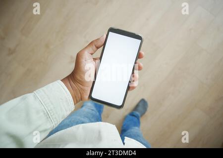 pov shot of young man hand using smart phone at home  Stock Photo
