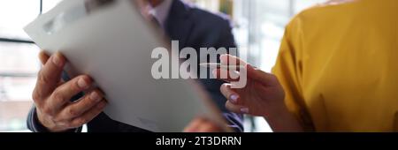 Man in business suit works in office with female client Stock Photo