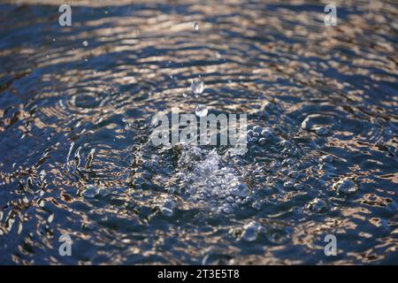 Dancing water drops in fountain with evening light Stock Photo