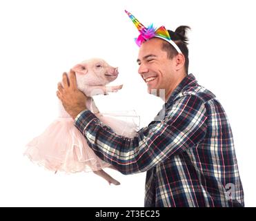 pink miniature pig and man in front of white background Stock Photo