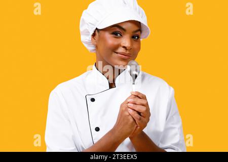 Smiling Young Black Chef Woman Using Spoon As Microphone Stock Photo
