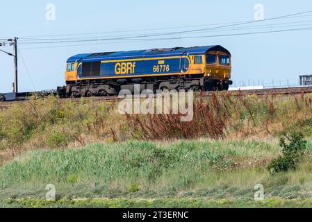 GB Railfreight Class 66 diesel electric 66776 hauling a freight train on the east coast line of Greater Anglia railway near Manningtree, Essex, UK Stock Photo