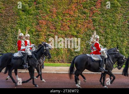 London, UK. 25th Oct, 2023. Cavalry of the Life Guards pass the Autumn coloured virginia creeper on the face of the Admiralty Citadel on their way to Changing of the Guard in Horse Guards Parade. Credit: Malcolm Park/Alamy Live News Stock Photo