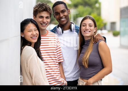 Beautiful young men and women smiling and looking at camera.Diverse group of joyful millennial people staring happy at camera. Stock Photo