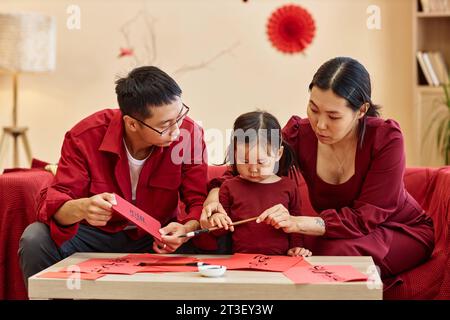 Portrait of Chinese family writing with ink and brush doing traditional calligraphy Happiness and good wishes Stock Photo