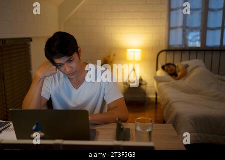 A man is working late at night. Working at night concept. Stock Photo