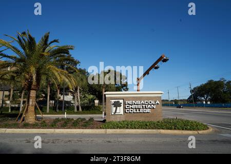 Pensacola Christian College entrance sign in Pensacola, Florida, USA, with palm trees and a clear blue sky. Stock Photo