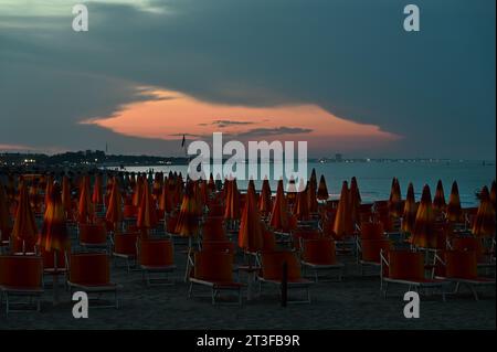 Closed umbrellas on Cesenatico beach Riviera Adriatica, Italy Stock Photo