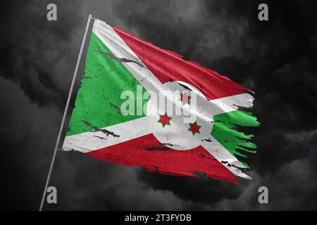 Burundi torn flag on dark sky background. Stock Photo