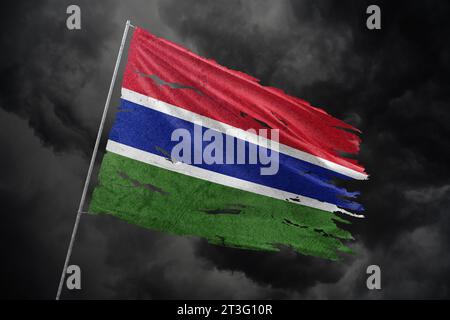 Gambia torn flag on dark sky background. Stock Photo