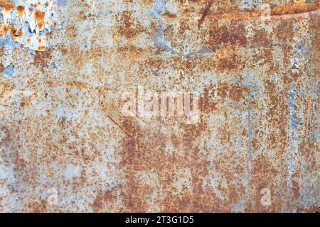 Texture of rust showing through on a painted metal old sheet with peeling paint. Stock Photo