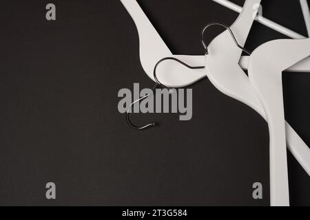 White wooden clothes hangers on black background. Sale and shopping concept. Black Friday. copy space Stock Photo