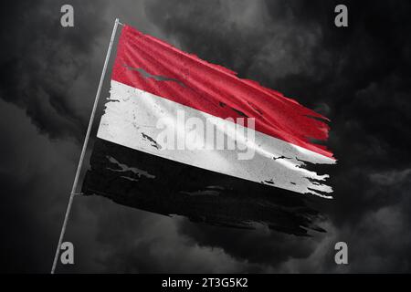Yemen torn flag on dark sky background. Stock Photo
