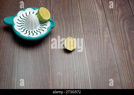 Lemon juicer with sliced Lemon isolated on wooden background. Stock Photo