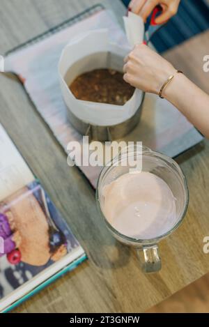 woman is holding glass of whites cream for the cake. fills the cake with cream. High quality photo Stock Photo