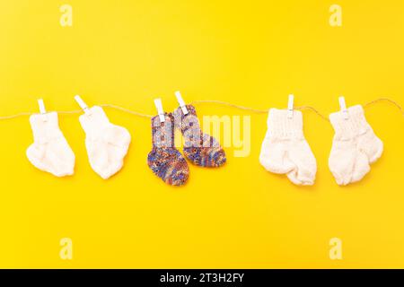 November 17, World Prematurity Day, Normal size and Tiny socks on rope with yellow background. Stock Photo