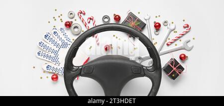 Steering wheel with Christmas decor and tools on light background Stock Photo