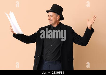 Mature actor reading film script on beige background Stock Photo