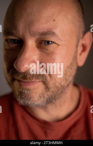 In this close-up shot, a middle-aged man in his 40s, unshaven and wearing an affable expression, showcases his regular appearance Stock Photo