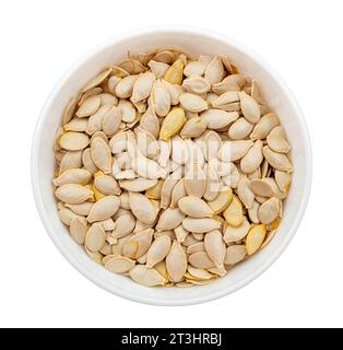 Pumpkin seeds in husks on a plate on a white background. View from above. Unshelled pumpkin seeds isolate Stock Photo