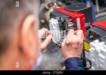 Montage Engineer fixing equipment on stand with metal probe screw driver, head and hand view. High quality photo Stock Photo