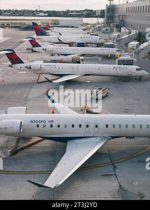 a row of Delta Air Lines regional jets on gates at La Guardia Airport one spring morning Stock Photo