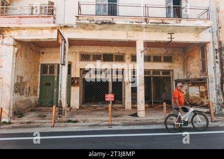 a tourist with a bicycle touring the abandoned city of Varosha, Famagusta, Cyprus. An empty shop can be seen behind Stock Photo