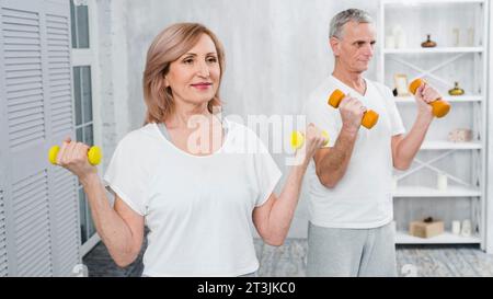 Happy senior couple exercising using dumbbells Stock Photo