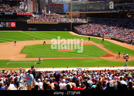 A crowd enjoys a baseball game on a sunny summer day, watching the Minnesota Twins at Target Field Stock Photo