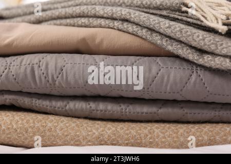Stack of different folded blankets, closeup. Home textile Stock Photo